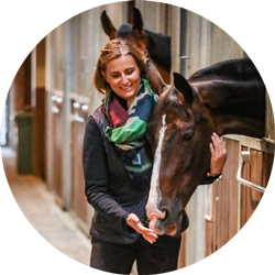 Lieselot Hamerlinck CEO of Pegasus Holding in een stal bij een paard